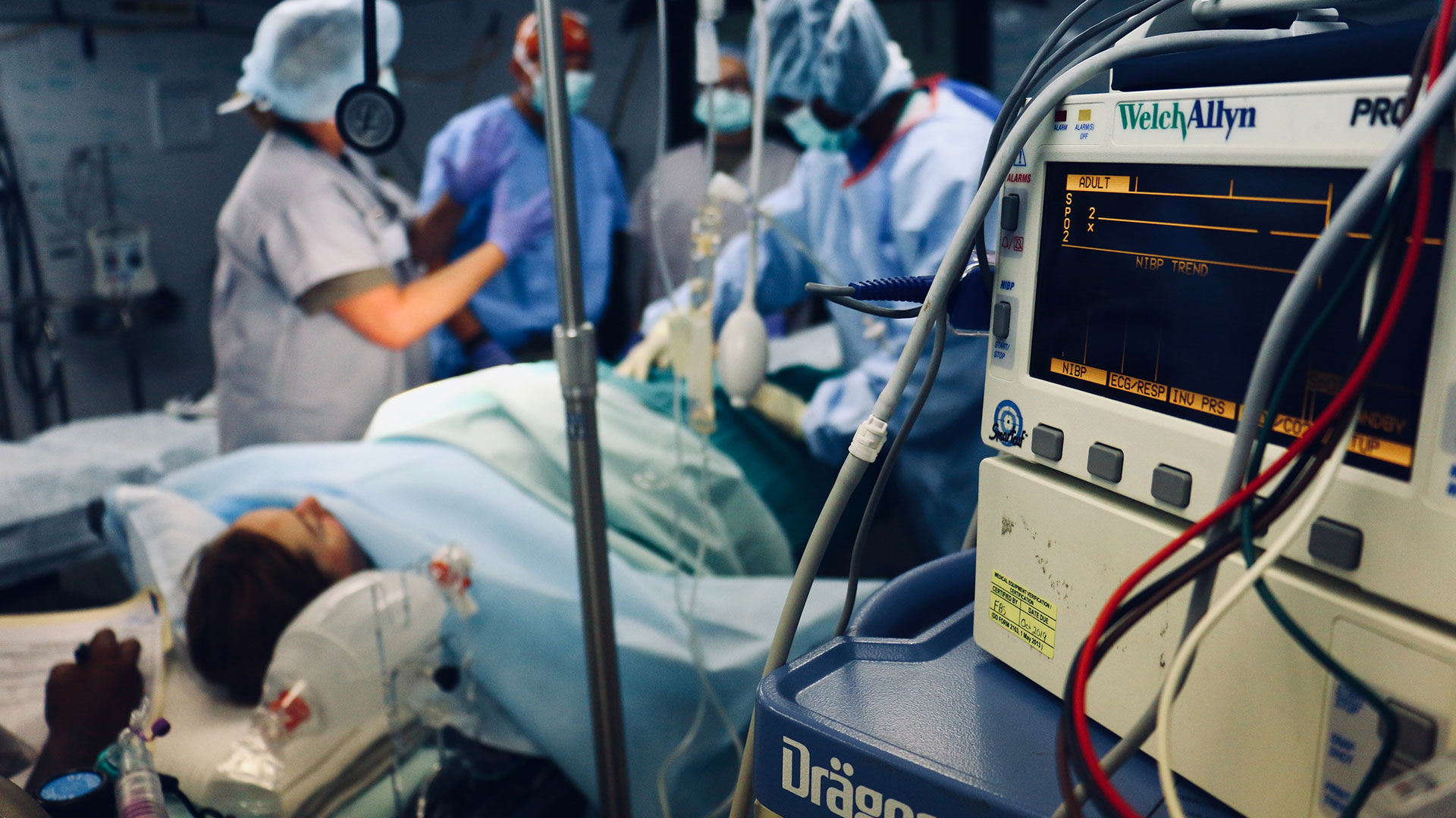 medical professionals completing a procedure with close up of anesthesia machine